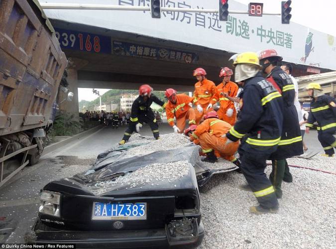 В Китае грузовик со щебнем опрокинулся и раздавил легковушку